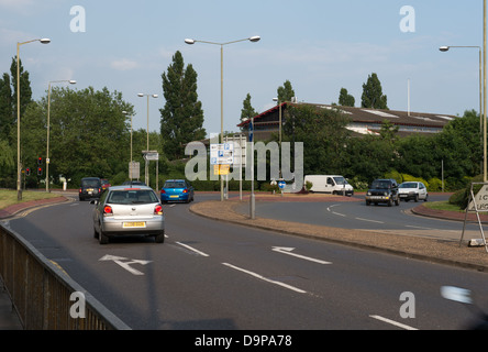 Véhicules approchant un rond-point de jonction avec différents signes Banque D'Images