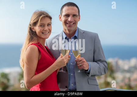 Heureux couple clinking champagne Banque D'Images