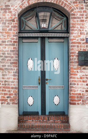 Belle porte en bois bleu avec des ornements encadré dans une redbricked wall Banque D'Images