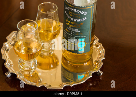 Une bouteille de 15 ans single malt whisky de la distillerie Arran sur un plateau d'argent avec 2 verres à moitié plein Banque D'Images