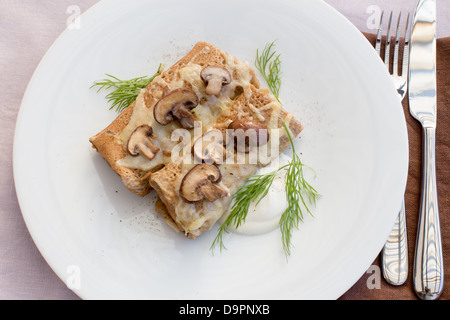 Crêpes salées aux champignons, fromage et crème sure. Banque D'Images