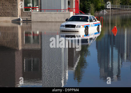 Une voiture de police piégée dans un stationnement par des eaux qui montent rapidement tandis que la police évacuait le quartier Sunnyside de Calgary, en Alberta, au Canada. Banque D'Images