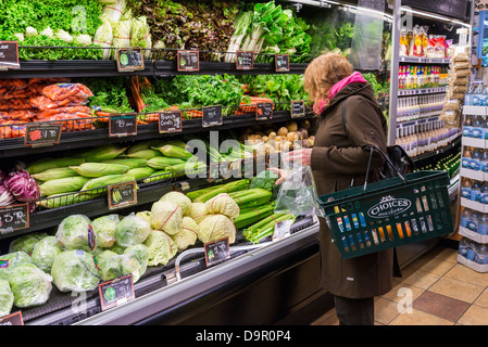 Femme au rayon des fruits et légumes épicerie Banque D'Images