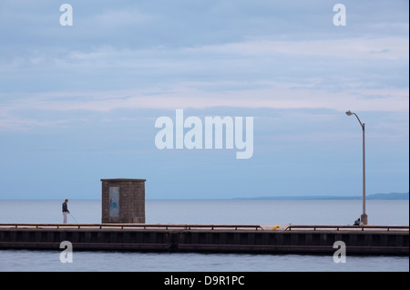 Un homme seul la pêche le long d'un quai à Hamilton, Ontario, Canada. Banque D'Images