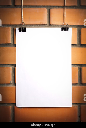 Blank white poster sur une corde, mur de brique sur l'arrière-plan Banque D'Images