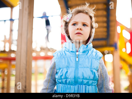 Petite fille pensive sur l'aire de jeux Banque D'Images