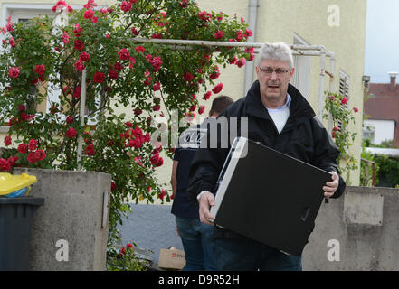Fellbach, Allemagne, 25 juin 2013. Un agent de police porte un ordinateur saisi sur un raid sur chambre à Fellbach, Allemagne, 25 juin 2013. La police a fait une descente dans un immeuble résidentiel à tôt le matin. Les terroristes islamistes ont peut-être été la planification d'une attaque. Le Ministère Public Fédéral à Karlsruhe seulement confirmé qu'une enquête en raison de la suspicion de la préparation d'un acte séditieux de la violence a été entrepris. Dpa : Crédit photo alliance/Alamy Live News Banque D'Images