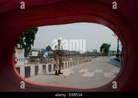 Srinagar Cachemire sous administration indienne, 25 juin 2013. Un Indien paramilitaire monte la garde sur une route pendant une grève et ristrictions à Srinagar le 25 juin 2013, le Premier Ministre indien Manmohan Singh est prévue pour faire une visite au monument du Cachemire administrée par les indiens en difficulté, un jour après que des militants lourdement armés ont tué huit soldats indiens dans l'attaque la plus meurtrière dans la région pendant cinq ans. (Sofi Suhail/ Alamy Live News) Banque D'Images