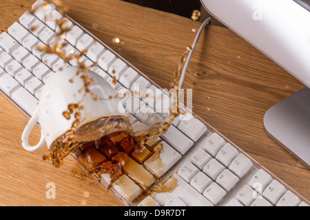 Tasse de thé renversé sur un clavier Banque D'Images