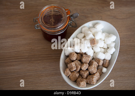 Morceaux de sucre dans un bol et le miel en Cafe Banque D'Images