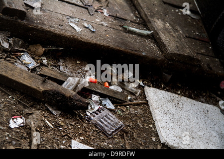 Aiguilles et d'autres utilisateurs de drogues sur l'attirail une sale plancher en bois. Banque D'Images