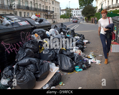 Les habitants de Brighton à pied de plus en plus passé des tas de détritus dans les rues, lors d'une grève par les travailleurs de refuser de la ville Banque D'Images