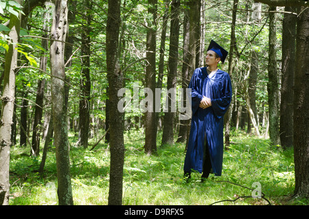 Graduate student standing in forest Banque D'Images