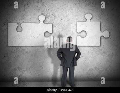 Businessman Trouver des pièces de puzzle Banque D'Images