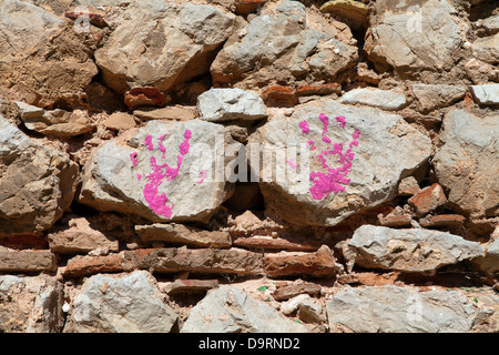 L'enfant handprint sur mur de pierre en peinture rose Banque D'Images