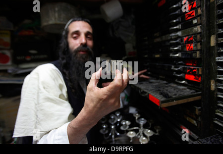 Yoel Krois, un Juif ultra-orthodoxe de Neturie Karta un groupe religieux qui s'est séparé du judaïsme normatif tenant des lettres de type métal pour l'impression en hébreu à son atelier dans le quartier de Mea Shearim, une enclave ultra-orthodoxe à Jérusalem Ouest d'Israël Banque D'Images