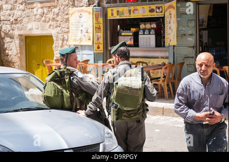 Israël, Jérusalem Vieille ville , quartier arabe musulmane , Via Dolorosa , deux soldats des forces armées 2 en uniforme s'appuyant sur chattiing voiture Banque D'Images