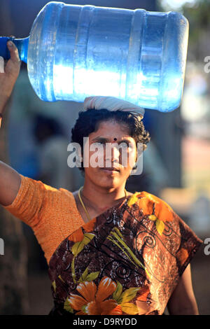 24 nov., 2012 - Bangalore, Karnataka, Inde - Une femme de village Hebbagodi transporter accueil bidons d'eau potable fraîche fournis par Naandi Eaux. Grandes entreprises multinationales ciblent de plus en plus bas de la pyramide, les pauvres, dans les pays en développement comme l'Inde à conduire la croissance future et les profits. (Crédit Image : © Subhash Sharma/ZUMAPRESS.com) Banque D'Images