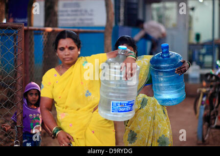 24 nov., 2012 - Bangalore, Karnataka, Inde - les femmes de village Hebbagodi transporter accueil bidons d'eau potable fraîche fournis par Naandi Eaux. Grandes entreprises multinationales ciblent de plus en plus bas de la pyramide, les pauvres, dans les pays en développement comme l'Inde à conduire la croissance future et les profits. (Crédit Image : © Subhash Sharma/ZUMAPRESS.com) Banque D'Images