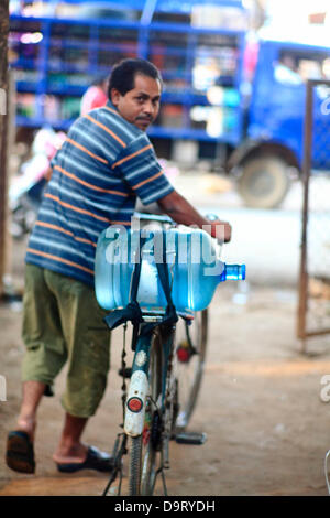 24 nov., 2012 - Bangalore, Karnataka, Inde - un habitant du village Hebbagodi porte accueil bidons d'eau potable fournie par les eaux Naandi. Les entreprises sont de plus en plus cibler le bas de la pyramide, les marchés pauvres, dans les pays en développement comme l'Inde à conduire la croissance future et les profits. (Crédit Image : © Subhash Sharma/ZUMAPRESS.com) Banque D'Images