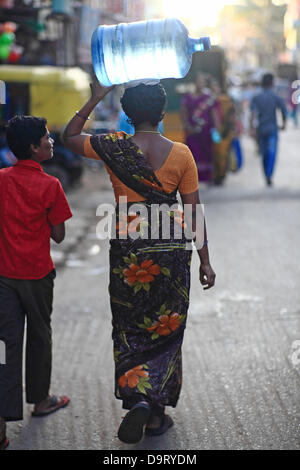 24 nov., 2012 - Bangalore, Karnataka, Inde - Une femme de village Hebbagodi transporter accueil bidons d'eau potable fraîche fournis par Naandi Eaux. Grandes entreprises multinationales ciblent de plus en plus bas de la pyramide, les pauvres, dans les pays en développement comme l'Inde à conduire la croissance future et les profits. (Crédit Image : © Subhash Sharma/ZUMAPRESS.com) Banque D'Images