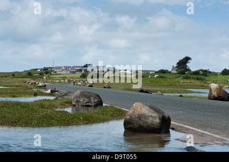 Le pont-jetée de Shell Island est couverte par l'eau de mer à marée haute. La vague s'écoule à travers une série de tuyaux de vidange. Banque D'Images