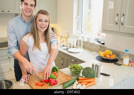 Couple smiling et de travail dans la cuisine Banque D'Images