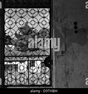 Vintage metal porte avec motif cercles et peeling mur d'une maison abandonnée. Banque D'Images