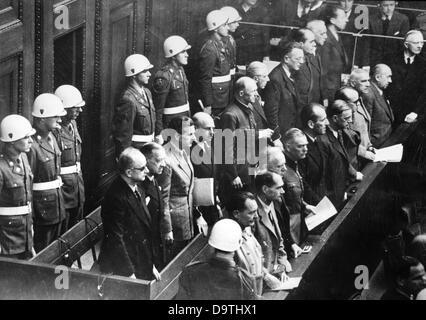 Les principaux accusés comme criminels de guerre du régime nazi sont entourés par la police militaire au procès de Nuremberg en 1946 en face de la Cour de Justice Militaire International. Première rangée de gauche ci-dessous. : Hermann Göring, Rudolf Hess, Joachim von Ribbentrop, Wilhelm Keitel, Ernst Kaltenbrunner, Alfred Rosenberg, Hans Frank, Wilhelm Frick, Julius Streicher, Walter Funk, Hjalmar Schacht. Deuxième rangée de gauche ci-dessus : Karl Dönitz, Erich Raeder, Baldur von Schirach, Fritz Sauckel, Alfred Jodl, Franz von Papen, Arthur Seys-Inquart, Albert Speer, Konstantin von Neurath, Hans Fritsche. Photo : Banque D'Images