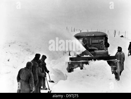 La Propagande nazie ! Sur l'arrière de l'image se lit comme suit : "nowblowers les chasse-neige et au travail. Chute de neige épais ramènes la piste presque infranchissable. Immédiatement, les véhicules sont utilisés pour parcourir la rue à la circulation. Inexorable, le ventilateur fonctionne à travers la neige profonde, qui est jeté à la marge de la route par un ventilateur." Image à partir du front de l'Est, 10 mars 1944. L'attaque contre l'Union soviétique par le Reich a été adoptée en juillet 1940 et préparé comme l'opération "Barbarossa" depuis décembre 1940. Le 22 juin 1941, l'invasion par la Wehrmacht allemande a commencé. Photo : Berlin Banque D'Images