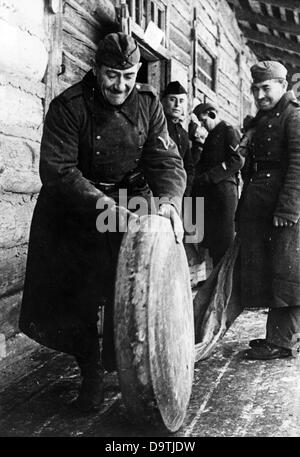 Texte de propagande du rapport national-socialiste au dos de la photo: "Les rouleaux de fromage à l'avant. Les troupes d'approvisionnement assurent constamment l'acquisition de nourriture ». Motif tiré du front de l'est (emplacement exact inconnu) le 18th mars 1942. Contrairement à l'information propagée en Allemagne, il y avait en règle générale pénurie d'offre sur le front oriental. Fotoarchiv für Zeitgeschichte Banque D'Images