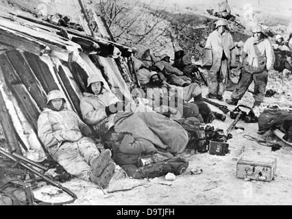 La propagande nazie! Sur le dos de l'image se lit: 'Action de la mesure de la tension en face de Leningrad. Après une journée de combat chaude, la troupe de choc se regroupe protégée par un remblai de chemin de fer pour attendre la nuit. Les armes et les munitions sont à portée de main. Une image du Front de l'est/Russie, 12 mars 1943. L'attaque contre la Russie b le Reich allemand a été convenu en juillet 1940 et a préparé depuis décembre 1940 comme l'opération Barbarossa. Le 22 juin 1941, l'invasion de l'Union soviétique par la Wehrmacht allemande a commencé. Fotoarchiv für Zeitgeschichte Banque D'Images