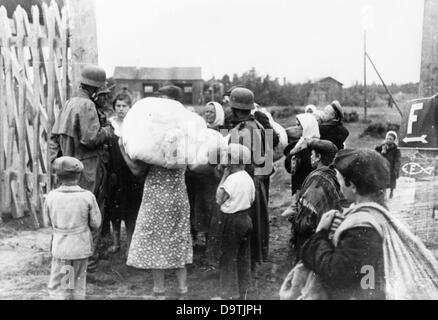 Texte de propagande du National socialiste reportage sur le dos de la photo: "Les réfugiés ont atteint leur village. Les postes allemands examinent leurs bagages et vérifient leur déclaration. Si tout est correct, ils sont autorisés à se déplacer à nouveau dans leurs maisons". Motif tiré du front de l'est le 4th août 1941. L'attaque de la Wehrmacht allemande contre l'Union soviétique le 22nd juin 1941 se déroule sous le nom d'opération Barbarossa. Fotoarchiv für Zeitgeschichte Banque D'Images