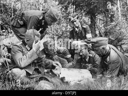 La Propagande nazie ! Sur l'arrière de l'image se lit comme suit : "Un gang a été détruit. Sur une petite clairière un post de combat a été érigée. Les deux dirigeants de l'opération, deux généraux, tenir une réunion avec les officiers des unités de service.' de droit du Front de l'Est/Russie, publié le 1 octobre 1942. Depuis l'été 1942, les Allemands n'étaient pas autorisés à utiliser le terme "partisans" pour des raisons psychologiques. Au lieu de cela, des termes comme 'Gang', 'bandits', et 'combat' gang ont été employées. L'attaque contre l'Union soviétique par le Reich a été adoptée en juillet 1940 et préparé comme l'opération "Barbarossa" Banque D'Images