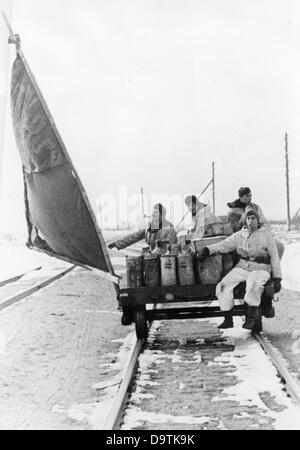 La Propagande nazie ! Sur l'arrière de l'image se lit comme suit : 'Railroad tie marins. Des munitions et des fournitures sont portées à l'postes avancés avec un "chariot" en difficulté sur les chemins de fer détruits par la créativité de nos soldats. Une forte brise va sur le paysage plat et entraîne le chariot. - Le joint a été fait d'une couverture et deux moitiés de logement - Le chariot a été transformé en un yacht et le chariot à l'approvisionnement des soldats en première ligne avec tout le nécessaire." Droit du Front de l'Est, 24 avril 1943. L'attaque de l'Union soviétique par le Reich a été adoptée en juillet 1940 et Banque D'Images