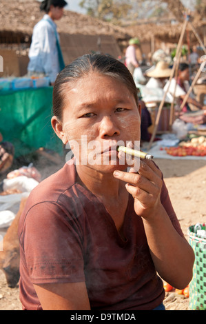 Femme birmane fumeurs un cheroot vert dans un marché Myanmar (Birmanie) Banque D'Images