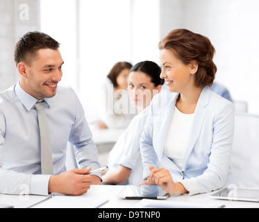 E monde colleagues talking in office Banque D'Images