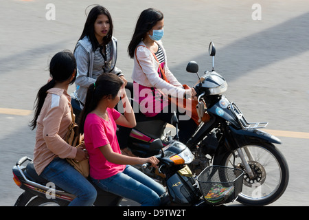 Les jeunes filles en moto sur le bord de la rivière à Kampot, Cambodge Banque D'Images