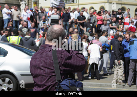 Un homme à prendre des photos lors d'une manifestation de l'EDL, Newcastle upon Tyne. Des foules de gens en arrière-plan, photographe à l'avant. Banque D'Images