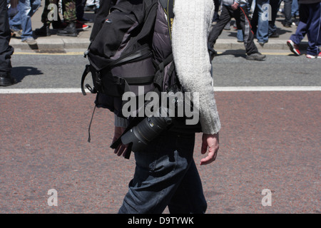 Un photographe, l'homme avec l'appareil photo de l'équipement, en passant devant une foule lors d'une manifestation de l'EDL à Newcastle upon Tyne. Banque D'Images