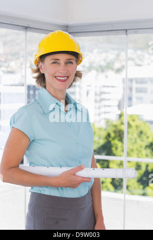 Architect looking at camera with Helmet et du plan directeur Banque D'Images