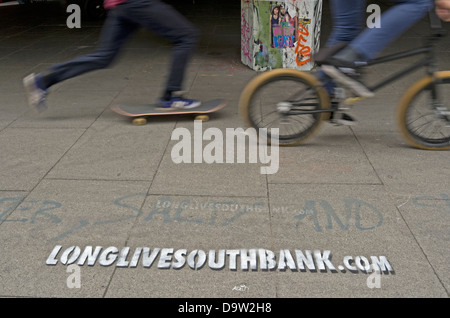 Un skateur professionnel et BMXer ride passé un schéma, la promotion de la longue vie à South Bank skate park à Londres. Banque D'Images