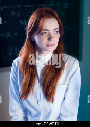 Close-up de la belle Rousse femme assistant avec un tableau noir avec des formules sur l'arrière-plan Banque D'Images