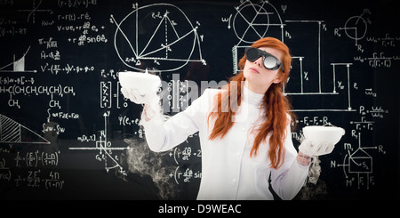 Young female scientist comparant deux pots devant un tableau rempli de formules chimiques dans le laboratoire de chimie Banque D'Images