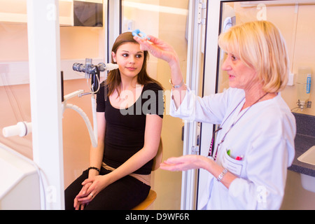 Examen annuel d'une jeune fille de 22 ans souffrant de mucoviscidose respirer dans un spiromètre. L'hôpital de Limoges, France. Banque D'Images