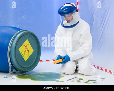 Close-up of female scientist wearing white masque et une combinaison de protection, de mesurer le niveau de contamination d'un biohazard acciden Banque D'Images