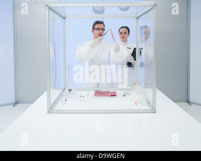 Image d'un homme et femme reasearching scientifique équipés de vêtements de protection sur certains sujets à risque biologique dans un laboratoire. Banque D'Images