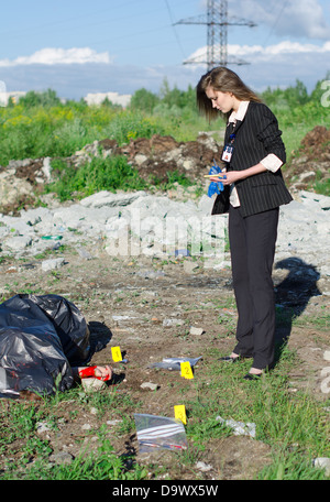 Jeune femme criminalist l'inspection des lieux du crime Banque D'Images