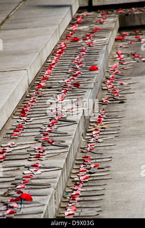 Petite croix de bois décoloré et coquelicots sur war memorial Banque D'Images