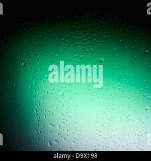 Les gouttes d'eau sur le verre derrière un fond vert Banque D'Images